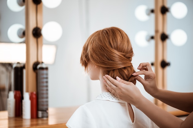 ビューティーサロンで赤毛の女性に髪型を作る女性美容師 無料の写真