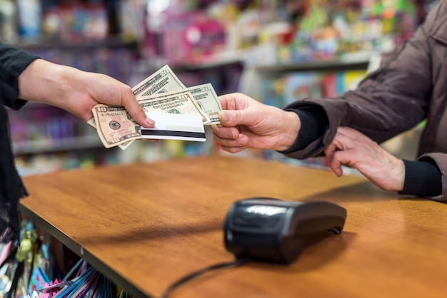 Premium Photo Female Hand Giving Dollars And Card To Cashier As Payment