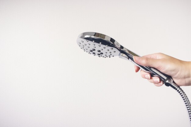 Premium Photo | Female hand hold shower head. white background.