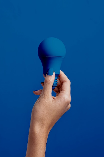  Female hand holding classic blue light bulb