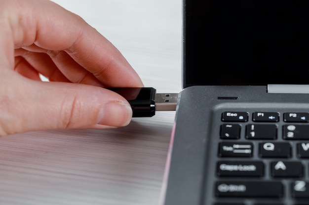 Premium Photo | Female hand inserting usb flash drive and laptop