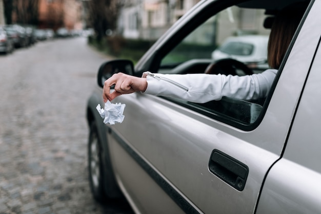 Premium Photo  Female hand throwing trash out of car window.