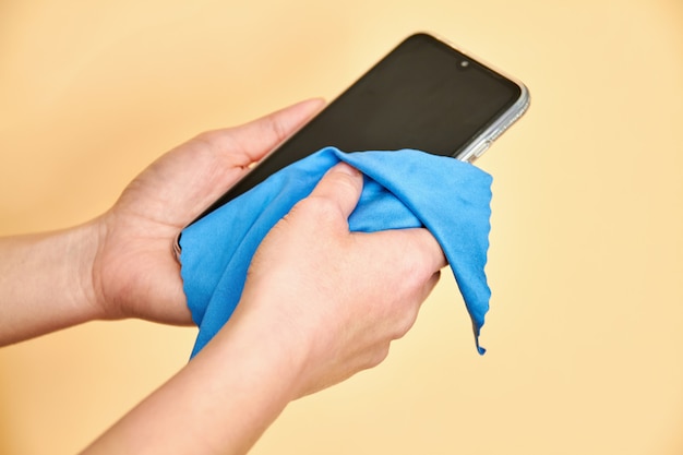 Female hands cleaning mobile phone for covid-19 disease prevention. virus prevention. Premium Photo
