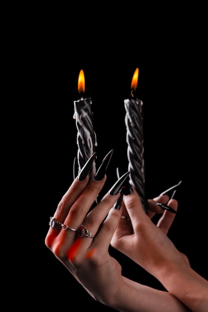 Premium Photo Female Hands With Long Nails Hold Burning Candles Witchcraft On Halloween