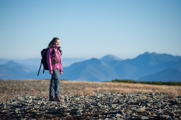 Premium Photo | Female hiker standing on the rocky mountain plato and ...