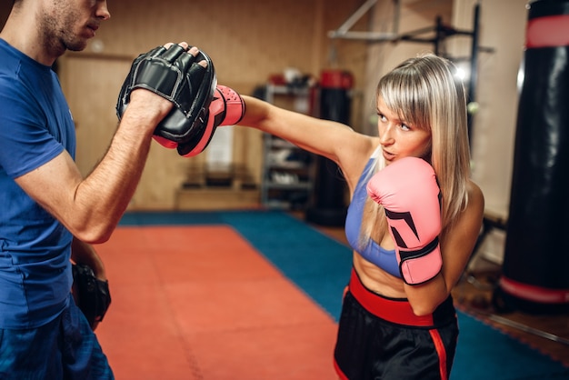 Premium Photo | Female kickboxer on workout with male personal trainer ...