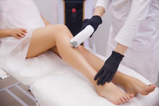 Female legs, woman in professional beauty clinic during laser hair removal Premium Photo
