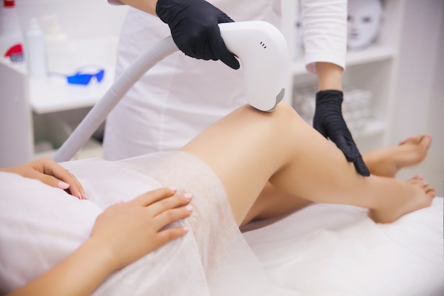 Female legs, woman in professional beauty clinic during laser hair removal Premium Photo