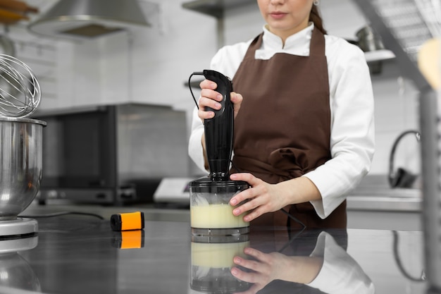 Premium Photo Female Pastry Chef Prepares A Mirror Icing For A Cake Whips It In A Blender