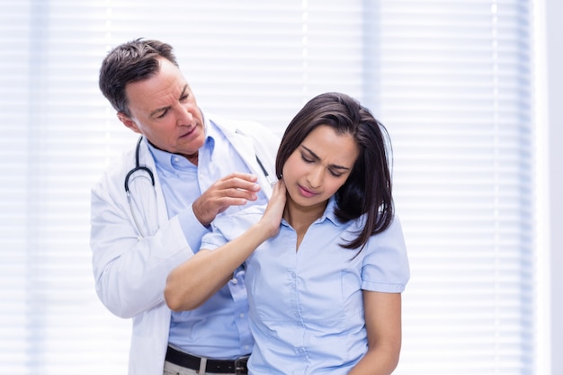 premium-photo-female-patient-showing-neck-pain-to-doctor