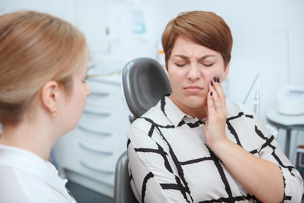 Premium Photo | Female patient suffering from toothache, having dental ...