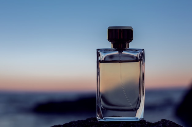 Premium Photo | Female perfume on sunset background