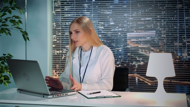 Premium Photo | Female psychologist in white coat making online video ...