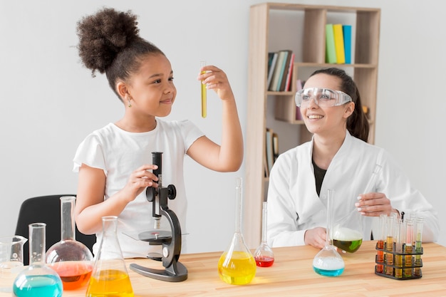 Premium Photo Female Scientist Observing Girl Experimenting With Chemistry 5356