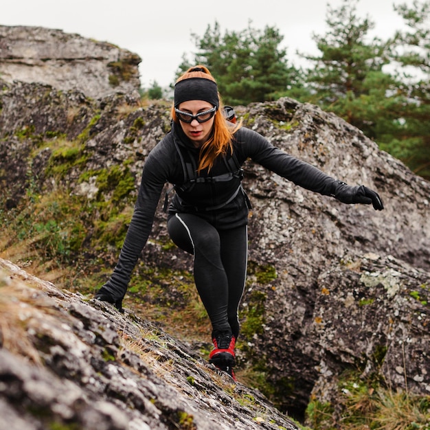 Free Photo Female sporty jogger climbing stones long shot