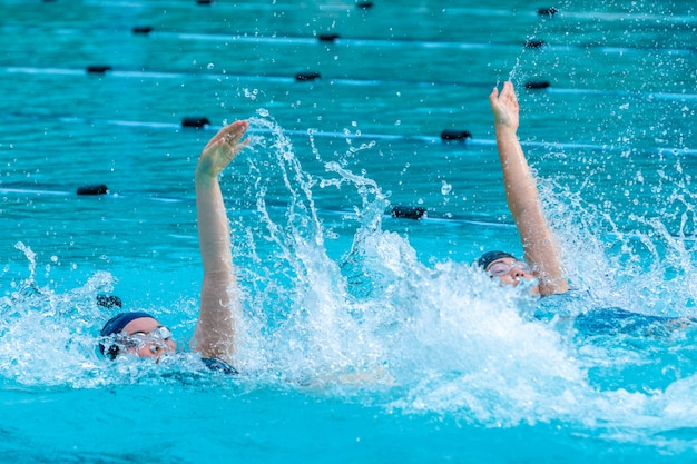 Premium Photo | Female swimmers swimming back stroke