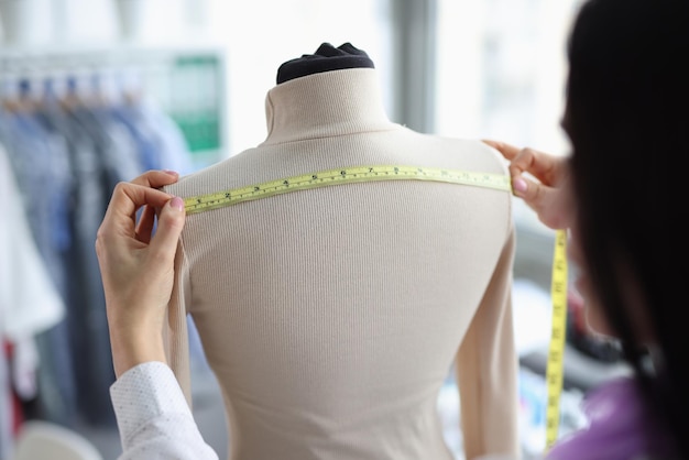 Premium Photo | Female tailor takes measurements on mannequin closeup