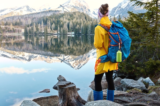 Free Photo | Female tourist stands on shore of beautiful mountain lake ...