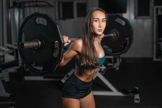 Female training with barbell, pumping legs Premium Photo