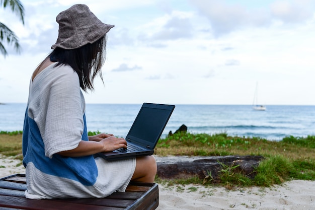 Female travelers are using laptop computer on the beach. Premium Photo