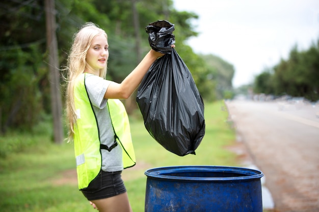 Premium Photo | Female volunteer holding a plastic waste bag, picking ...