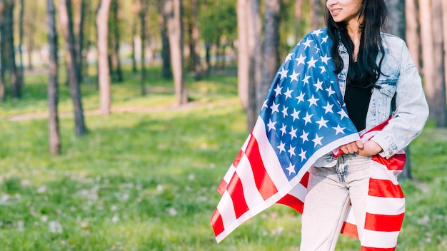 Female wrapped in american flag in park | Free Photo