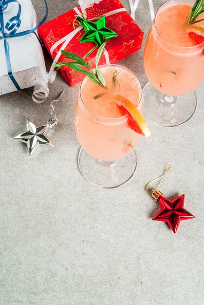 Premium Photo Festive Drink For Christmas Party Mimosa Cocktail With Champagne Grapefruit And Rosemary