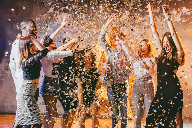 Festive friends in confetti together Free Photo
