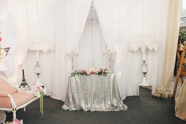 Festive Table With A Silver Tablecloth Of Sequins Next To Vases