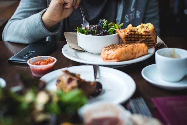 Filling breakfast burrito with salad in a coffeeshop Free Photo