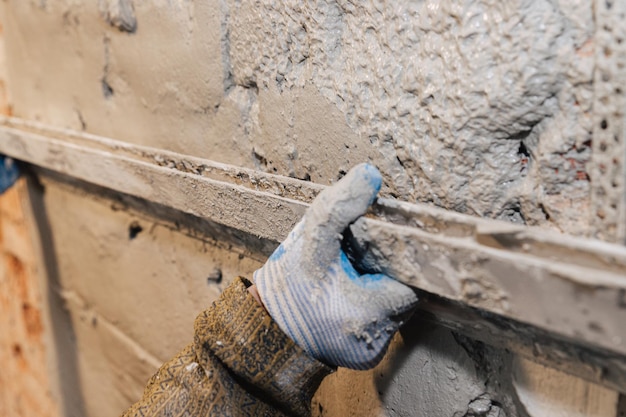 Premium Photo | The Final Stage Of Plastering The Walls. A Worker ...