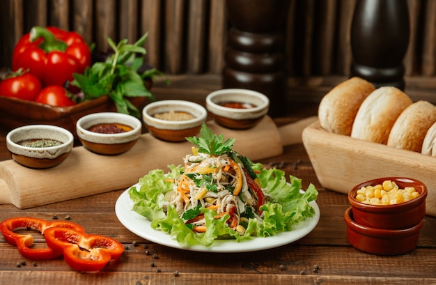 Finely chopped vegetable salad containing carrots, cabbage, tomatoes, cucumber and salad Free Photo