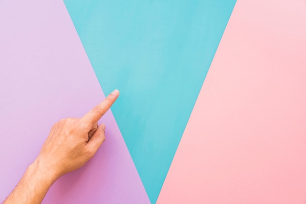 Finger above background with triangular shapes Free Photo