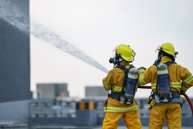 Premium Photo Firefighter Or Fireman Team Work Water Spray By High Pressure Nozzle To Fire