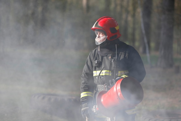 Premium Photo | Firefighter in smoke when extinguishing forest ...