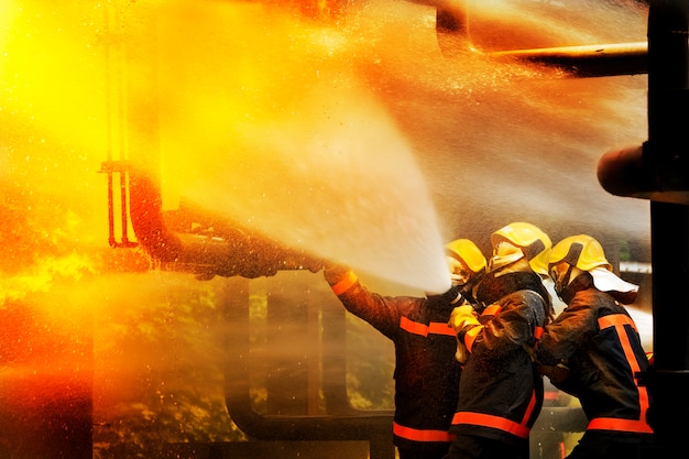 Premium Photo | Firemen Using Extinguisher And Water For Fighter Fire ...