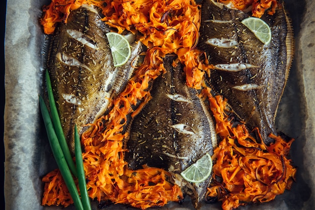 Fish Baked On Baking Sheet With Vegetables Close Up Flounder On Parchment With Carrots Lime And Green Onions Premium Photo