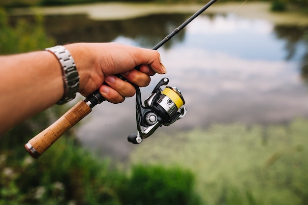 Free Photo | Fisherman's hand holding fishing rod at outdoors