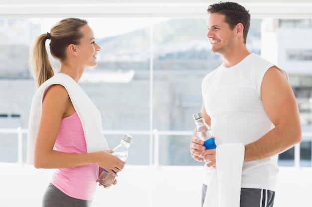 Premium Photo Fit Couple Holding Water Bottles And Towels In Exercise Room