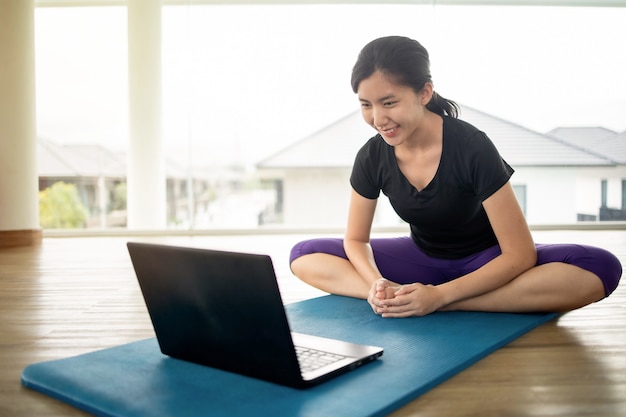 Premium Photo | Fit woman doing yoga and watching online tutorials on ...