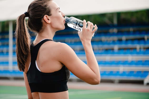 premium-photo-fit-woman-drinking-water-during-sport-training-on-the