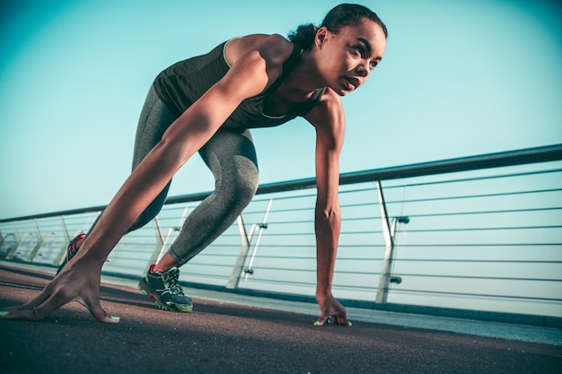 Premium Photo | Fit young athlete at the crouch start during her ...