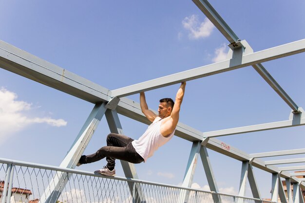 Fit Young Man Climbing On The Ceiling Of A Bridge Free Photo