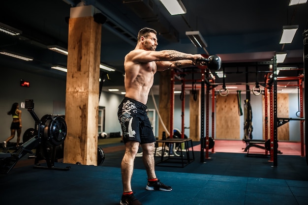 Premium Photo | Fitness man swinging kettlebells at the gym