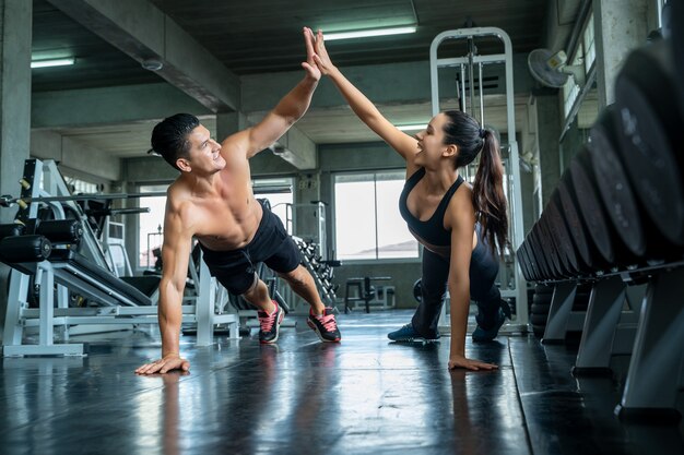 Premium Photo Fitness Man And Woman Doing Push Ups After The Training Session Fit Couple High Five After Workout In Club Gym