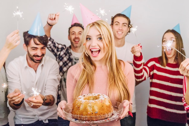ケーキの後ろに女の顔を持つ誕生日のコンセプト 無料の写真