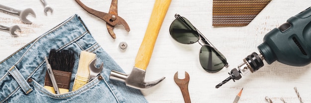 Flat lay accessories tools and clothing for worker on rusty white wooden for web banner. top view for labor or labour day, worker's day, father's day and home diy repair web banner concept. Premium Photo