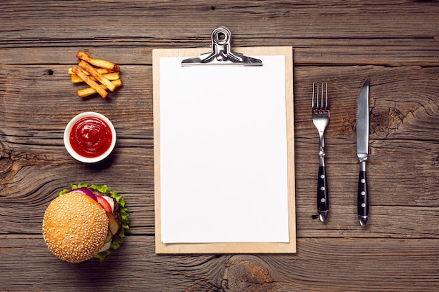 Flat lay burger with mock-up clipboard Free Photo