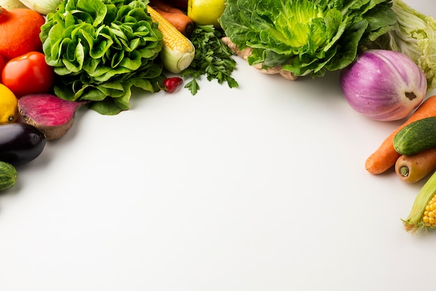 Flat lay colorful veggies on white background with copy space Free Photo