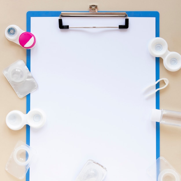 Flat lay composition with empty clipboard and lenses Free Photo